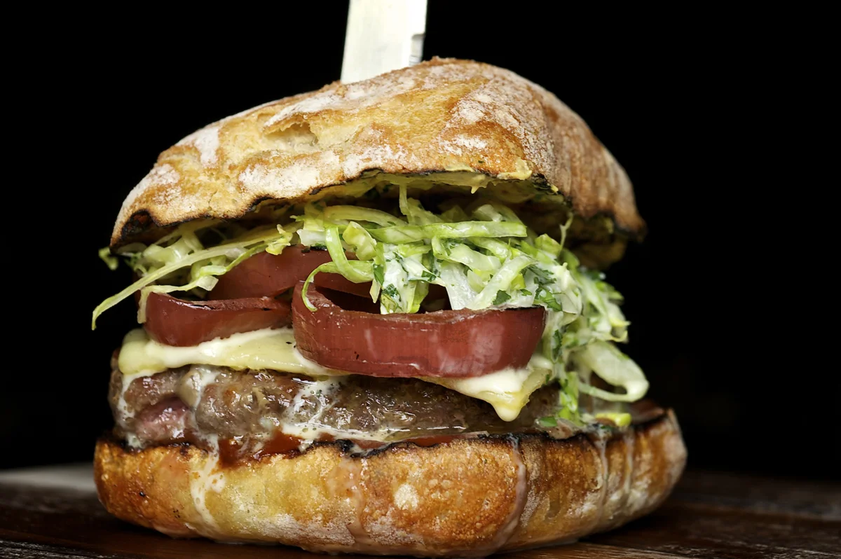 Le Pigeon signature dishes Le Pigeon Burger, Foie Gras Profiteroles, Beef Cheek Bourguignon, Rabbit & Snail Fricassee